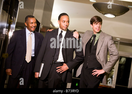 Three multi-racial businessmen standing in lobby of office building Stock Photo