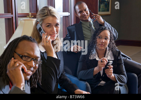 Four multi-racial business people using mobile phones Stock Photo