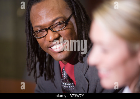 Two multi-racial businesspeople talking, focus on man Stock Photo