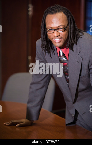 African American businessman leaning on conference table in boardroom Stock Photo