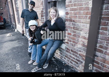 Portrait of urban youth hanging out in alleyway having fun drinking beer Stock Photo