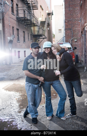 Urban youth hanging out in alleyway drinking beers and having fun Stock Photo