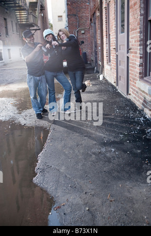 Urban youth hanging out in alleyway drinking beers and having fun Stock Photo