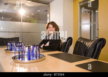 Asian businesswoman sitting at table in boardroom Stock Photo