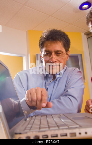 Middle-aged Hispanic businessman using laptop Stock Photo