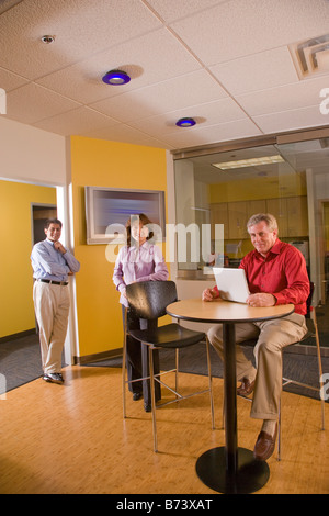 Three multi-racial businesspeople in office, looking at camera Stock Photo