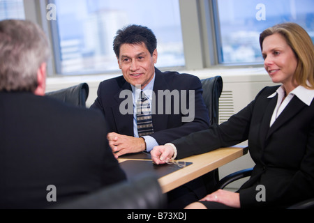 Middle-aged multi-racial business people negotiating in boardroom Stock Photo