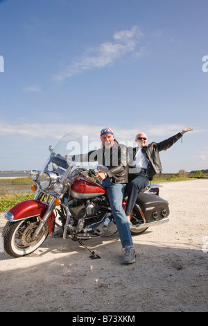 Portrait of happy senior biker couple sitting on motorcycle Stock Photo