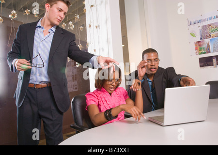 Three multi-racial office workers working on laptop Stock Photo