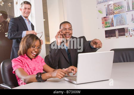 Three multi-racial office workers working on laptop Stock Photo