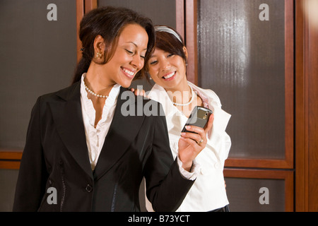 Businesswoman holding mobile phone with door in background Stock Photo