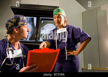 Veterinarians discussing medical records with animal x-rays in background Stock Photo