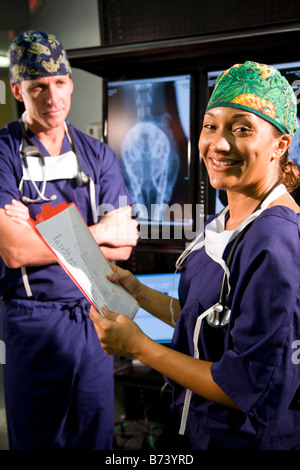 Veterinarians discussing medical records with animal x-rays in background Stock Photo