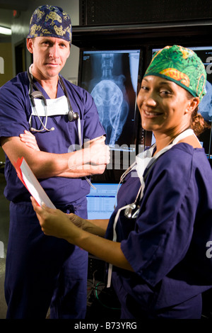 Veterinarians looking at medical records with animal x-rays in background Stock Photo