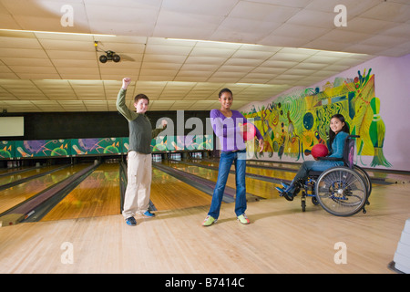 Multi-racial children with girl in wheelchair at bowling alley Stock Photo