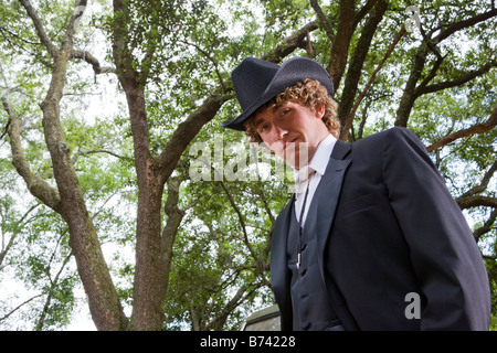 Portrait of young cowboy wearing full suit and cowboy hat outdoors Stock Photo