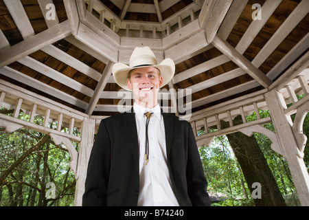 Portrait of young man in cowboy hat and suit standing in gazebo Stock Photo