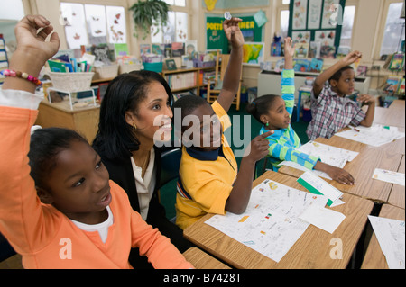 African students raising hands in classroom Stock Photo