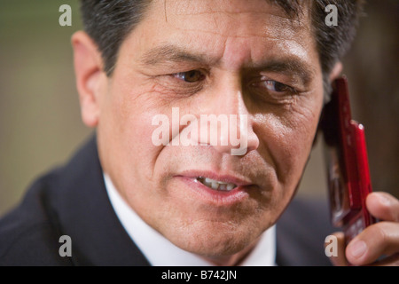 Close-up of mature businessman using mobile phone in office Stock Photo