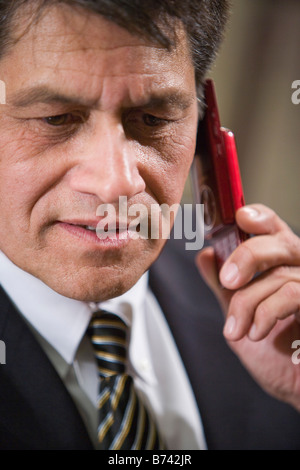 Close-up of mature businessman using mobile phone in office Stock Photo