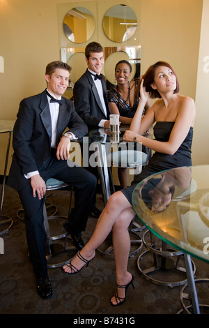 Two young couples in formalwear sitting in restaurant lounge Stock Photo