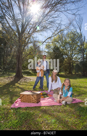 Young happy family in park with picnic basket Stock Photo