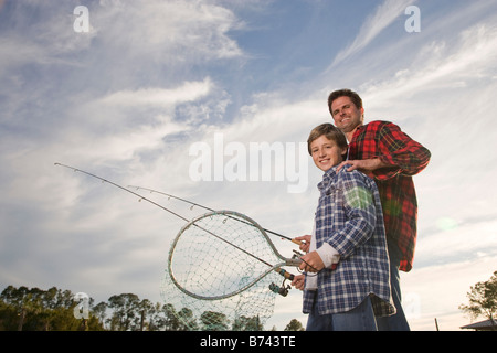 Happy son and father fishing, low angle view Stock Photo