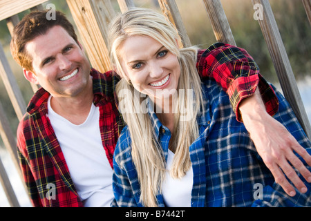 Portrait of couple relaxing on footbridge, smiling Stock Photo