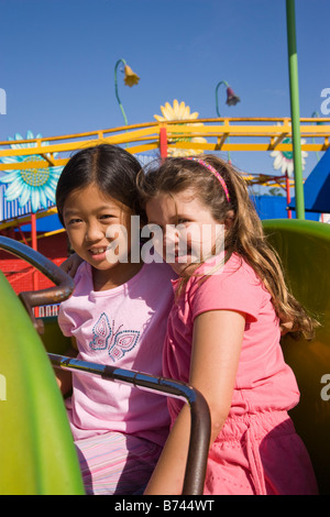 Children riding a roller coaster in an amusement park Stock Photo
