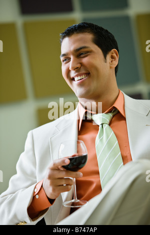 Hispanic businessman drinking red wine Stock Photo