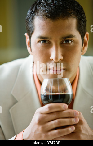 Hispanic businessman drinking red wine Stock Photo