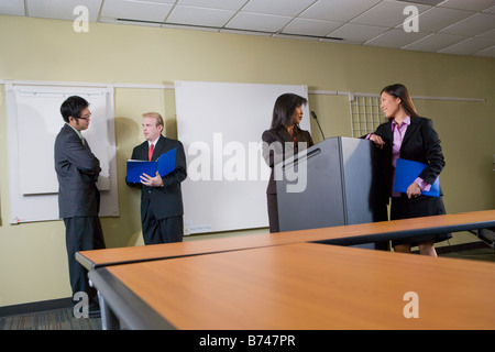 Four multi-ethnic businesspeople discussing files in boardroom Stock Photo