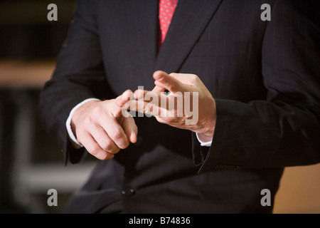 Mid section of Caucasian businessman counting fingers, close up Stock Photo
