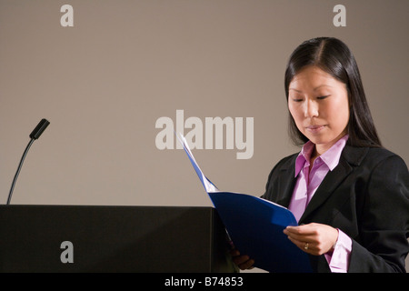 Young Asian businesswoman with presentation next to podium Stock Photo