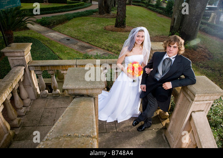 Happy young couple standing on outside balcony on wedding day Stock Photo
