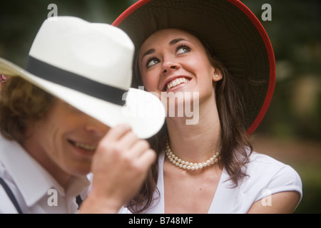 Close-up of happy young couple wearing hats, woman looking up and smiling Stock Photo