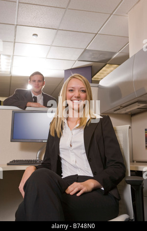 Two happy young office workers in cubicle Stock Photo