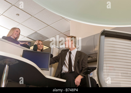Office workers chatting at cubicle desk Stock Photo