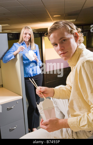 Two young office workers eating Chinese takeout food Stock Photo