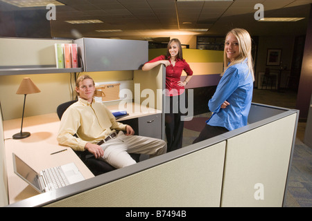 Three young co-workers in office cubicle, smiling Stock Photo