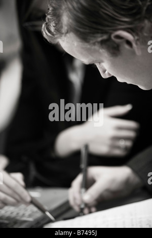 Close-up of young business people writing Stock Photo
