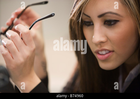 Close-up of young woman holding eyeglasses Stock Photo