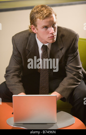 Young male office worker using laptop in office Stock Photo