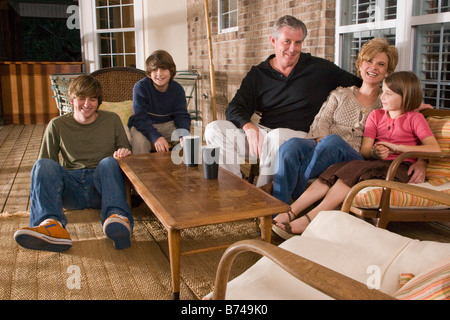 Portrait of family sitting together on porch Stock Photo