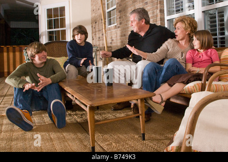Portrait of family sitting together on porch Stock Photo