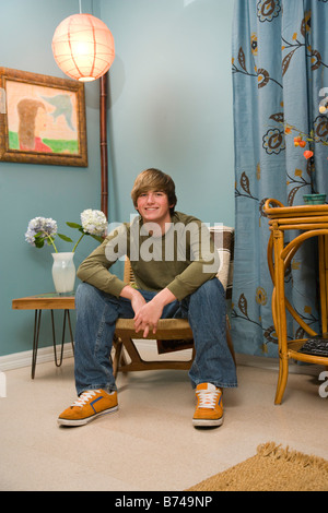 Teenage boy sitting in living room Stock Photo