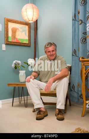 Middle-aged man sitting in living room Stock Photo