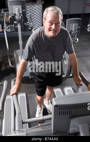 Senior man walking on treadmill at health gym Stock Photo