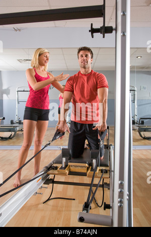 Young couple on Pilates exercise equipment in gym Stock Photo