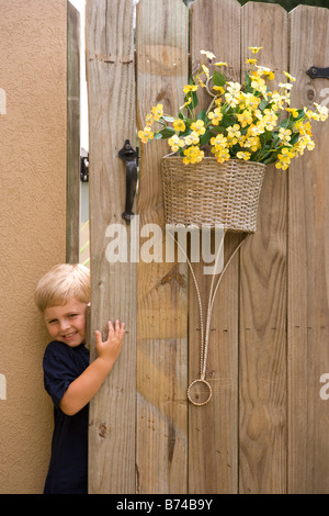 Little boy peeking through wooden door Stock Photo